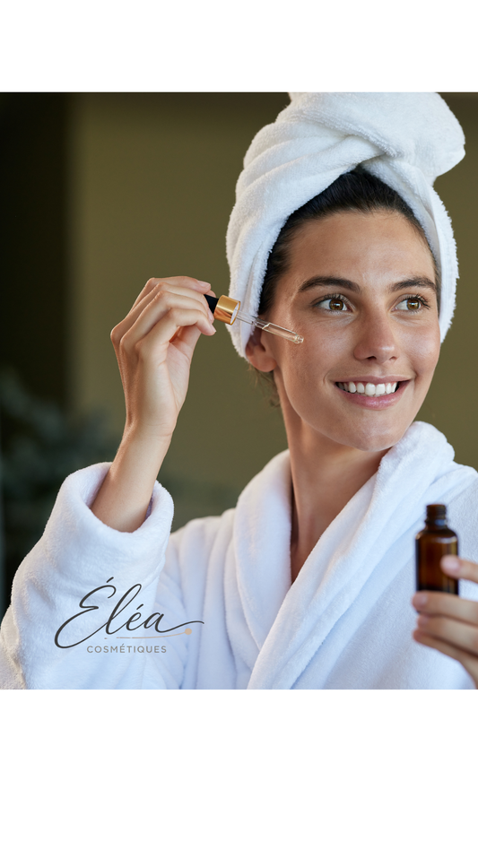 Femme en peignoir blanc appliquant un sérum doré sur son visage — routine beauté printemps