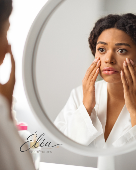Femme qui examine sa peau devant un miroir le matin — peau terne causes et solutions